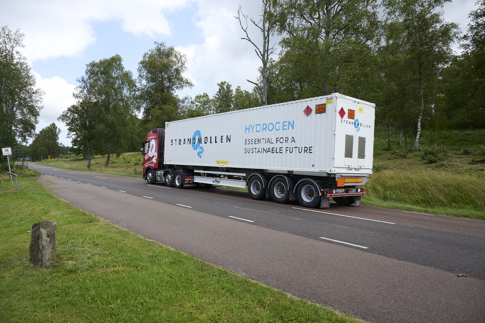 Lastbil med en brinttank og tanke i baggrunden